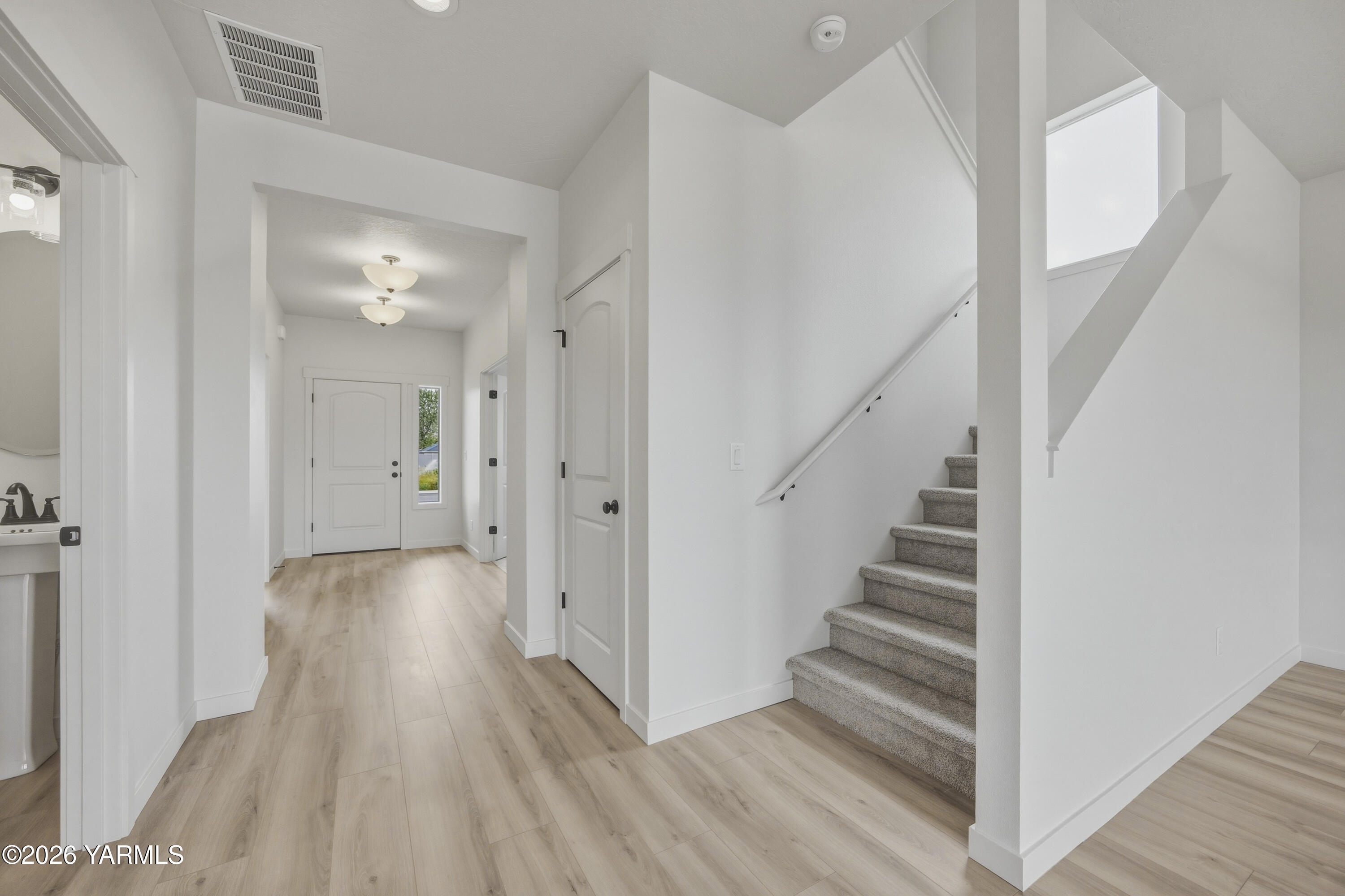 215 Packer Street Prosser, WA 99350 - Photo 3 of 45 a view of a hallway with wooden floor and staircase