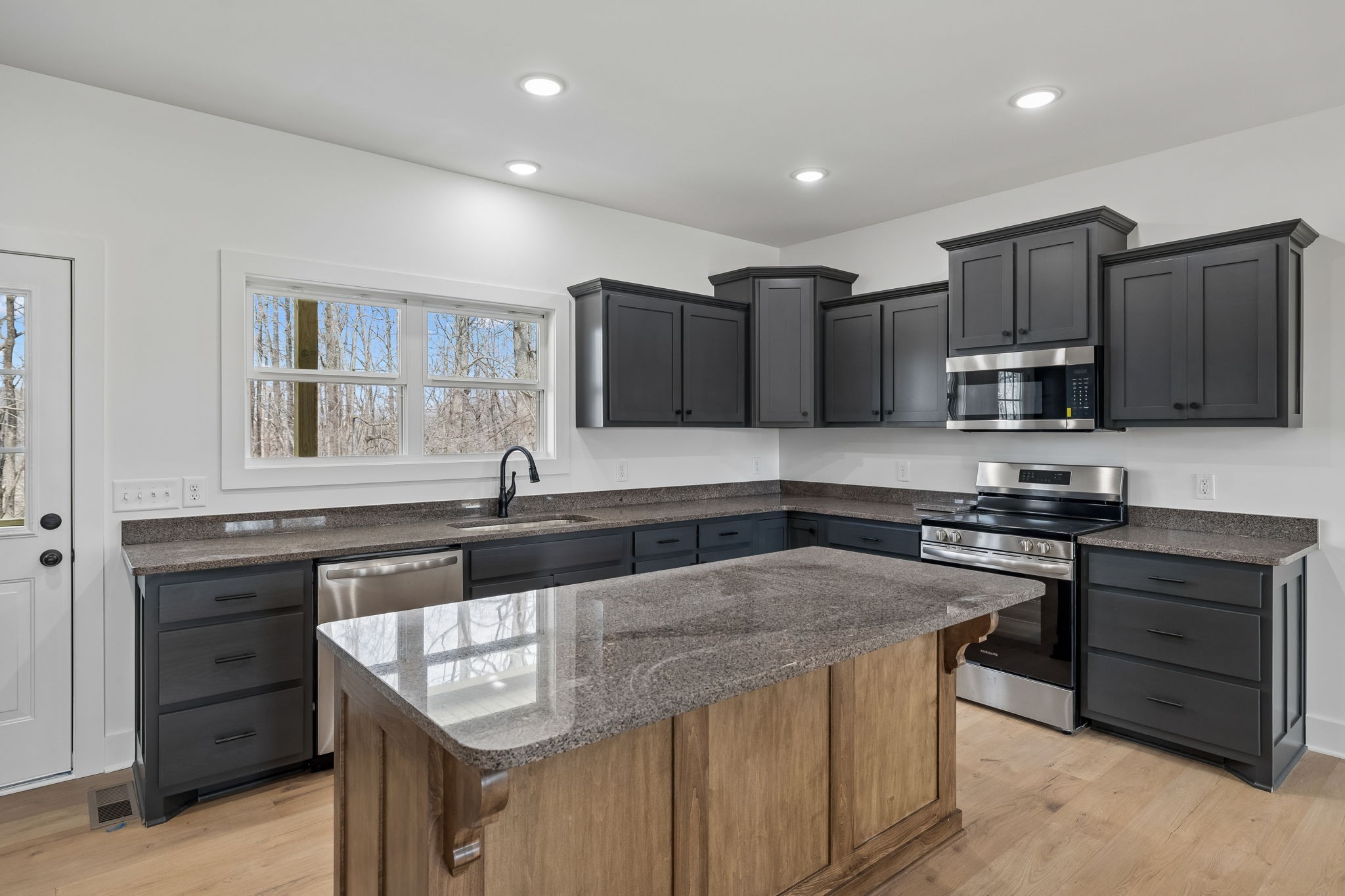 4083 Long Creek Road Lafayette, TN 37083 - Photo 10 of 36 a kitchen with stainless steel appliances granite countertop a sink stove microwave and refrigerator