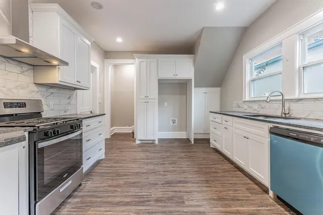 a large kitchen with stainless steel appliances granite countertop a stove and a sink