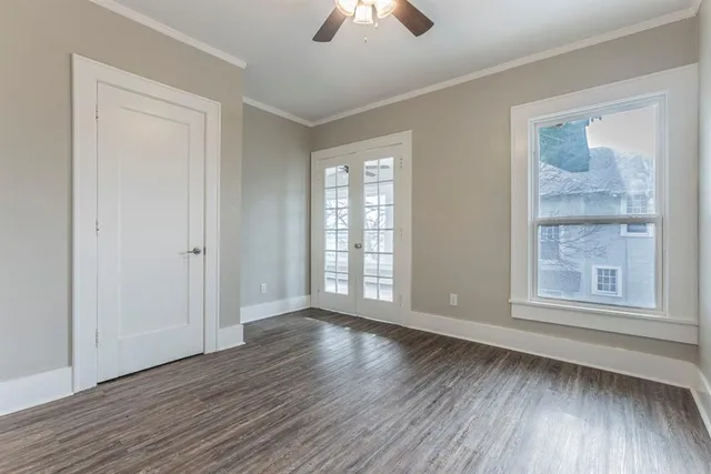an empty room with wooden floor and windows