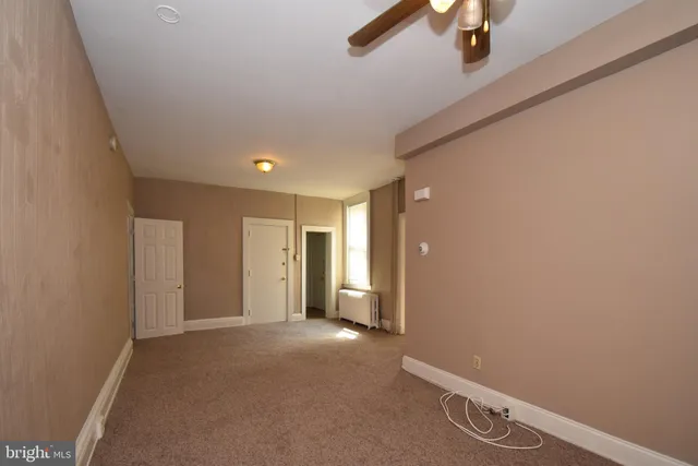 a view of a livingroom with a ceiling fan and window