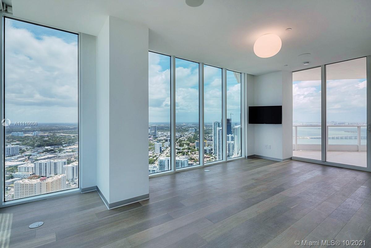 Edgewater Miami, FL 33137 - Photo 32 of 42 an empty room with wooden floor and windows
