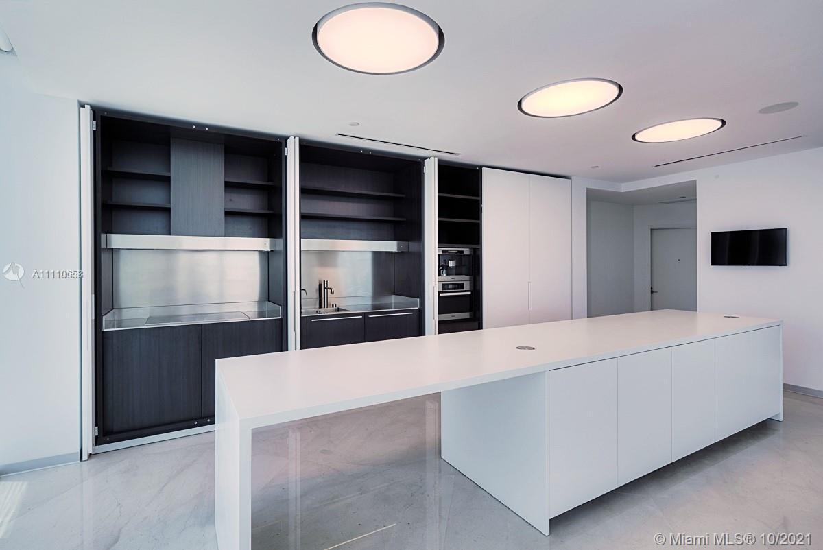 Edgewater Miami, FL 33137 - Photo 8 of 42 a living room with a projector and a refrigerator