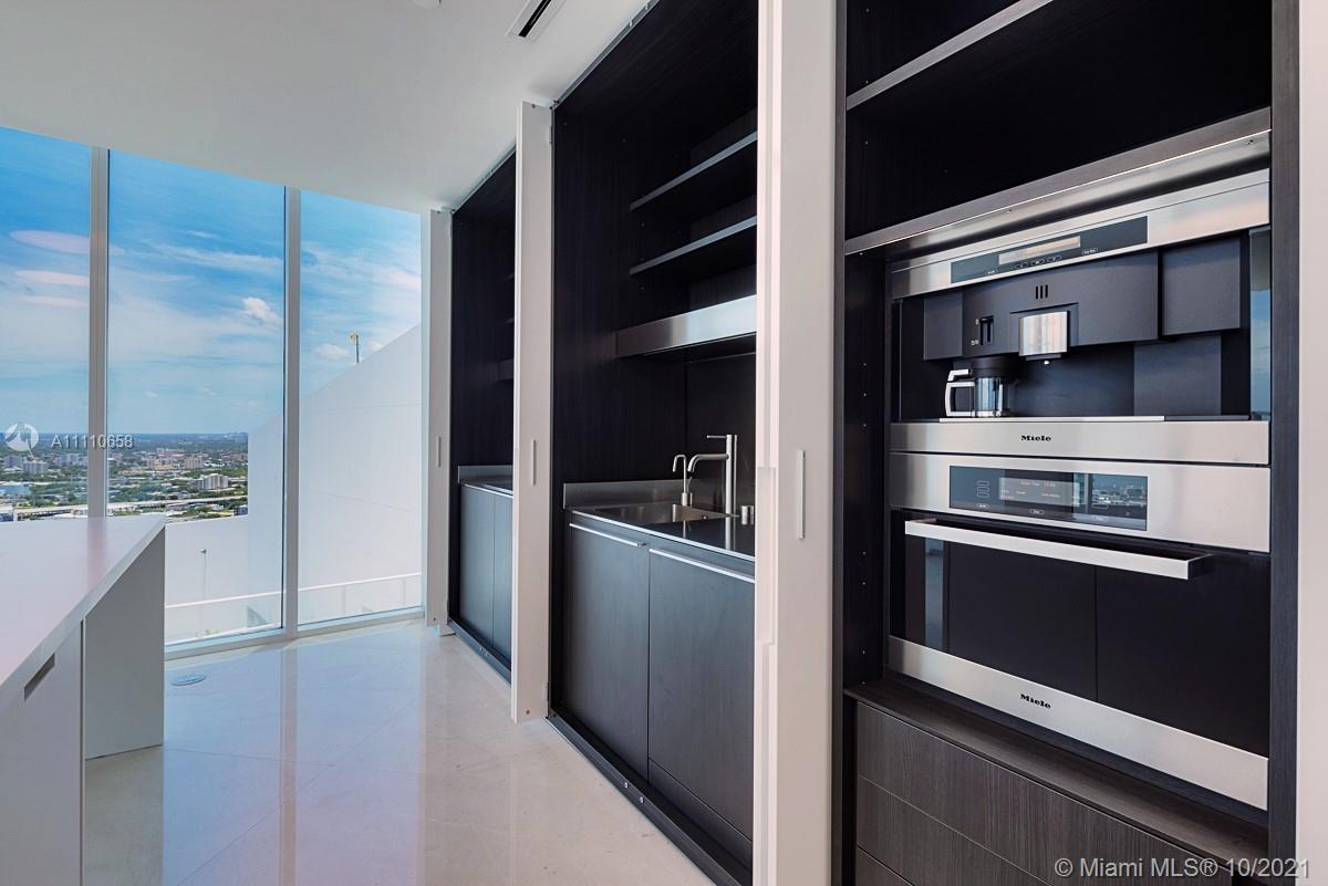 Edgewater Miami, FL 33137 - Photo 9 of 42 a kitchen with stainless steel appliances and cabinets