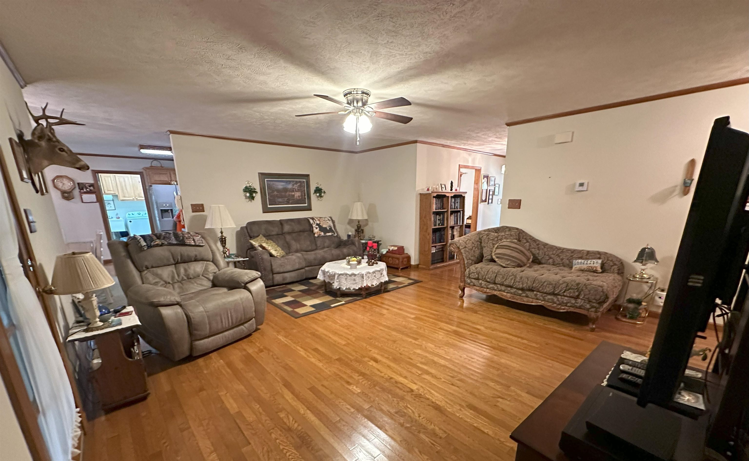 883 Crucifer Road Huron, TN 38345 - Photo 15 of 22 Living room featuring hardwood / wood-style floors, crown molding, a textured ceiling, and ceiling fan