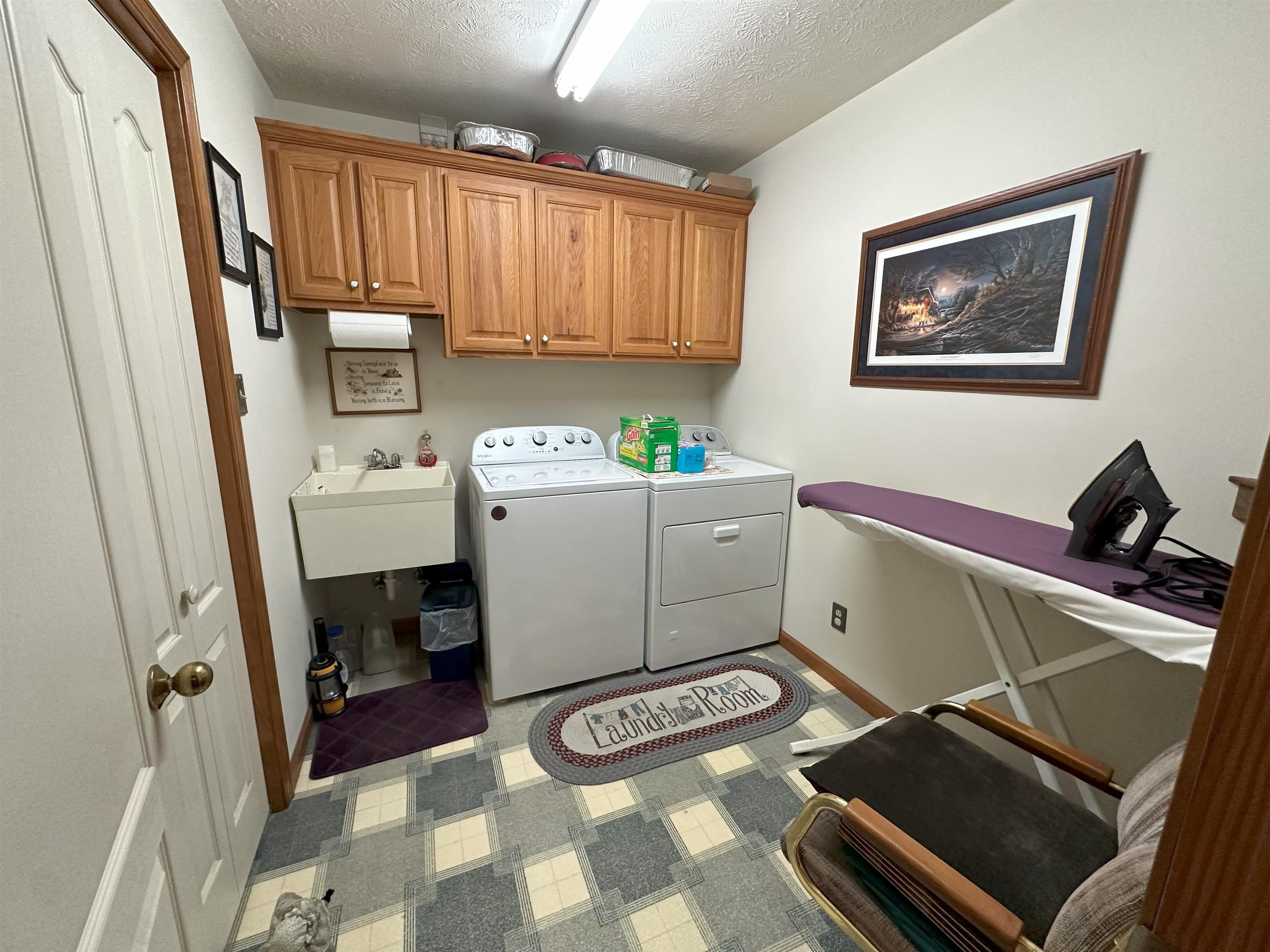 883 Crucifer Road Huron, TN 38345 - Photo 20 of 22 Laundry area with sink, a textured ceiling, cabinets, and separate washer and dryer