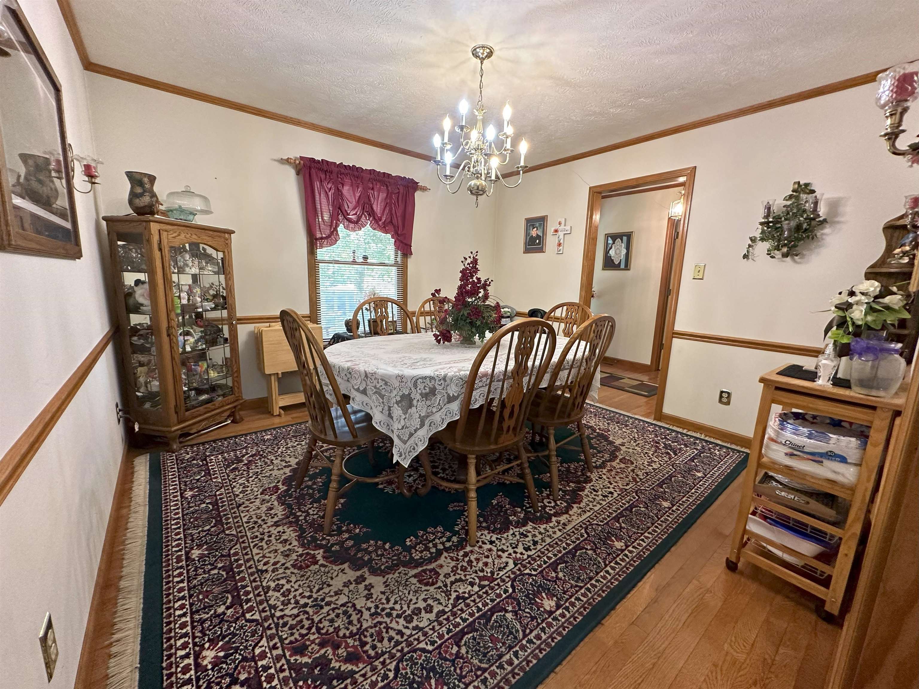 883 Crucifer Road Huron, TN 38345 - Photo 10 of 22 Dining area featuring ornamental molding, a notable chandelier, a textured ceiling, and wood-type flooring