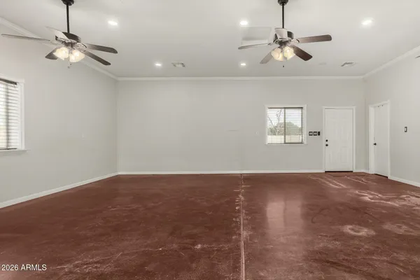 a view of an empty room with a chandelier fan and a window