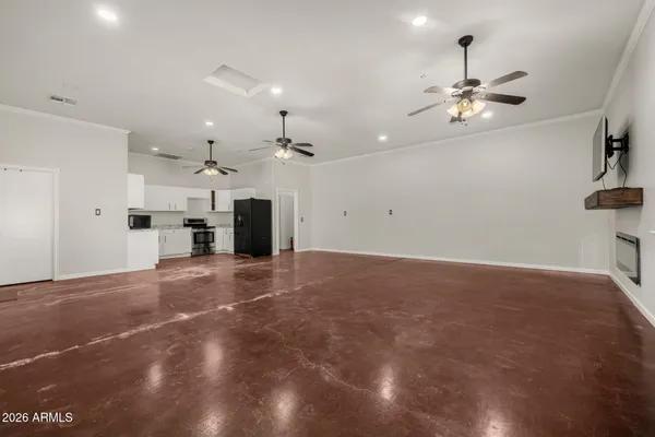 a view of a livingroom with a chandelier fan and kitchen view