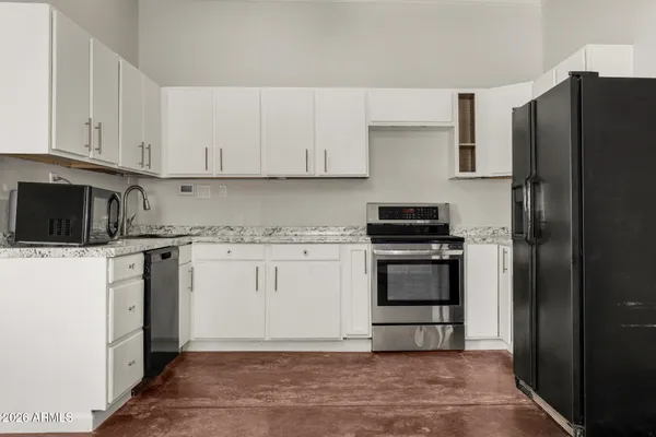 a kitchen with a refrigerator stove and white cabinets