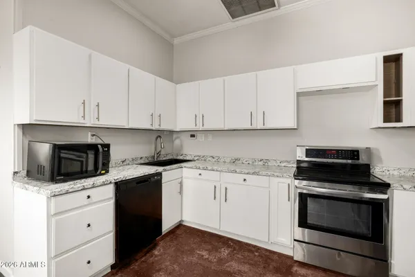 a kitchen with granite countertop white cabinets stainless steel appliances and a sink