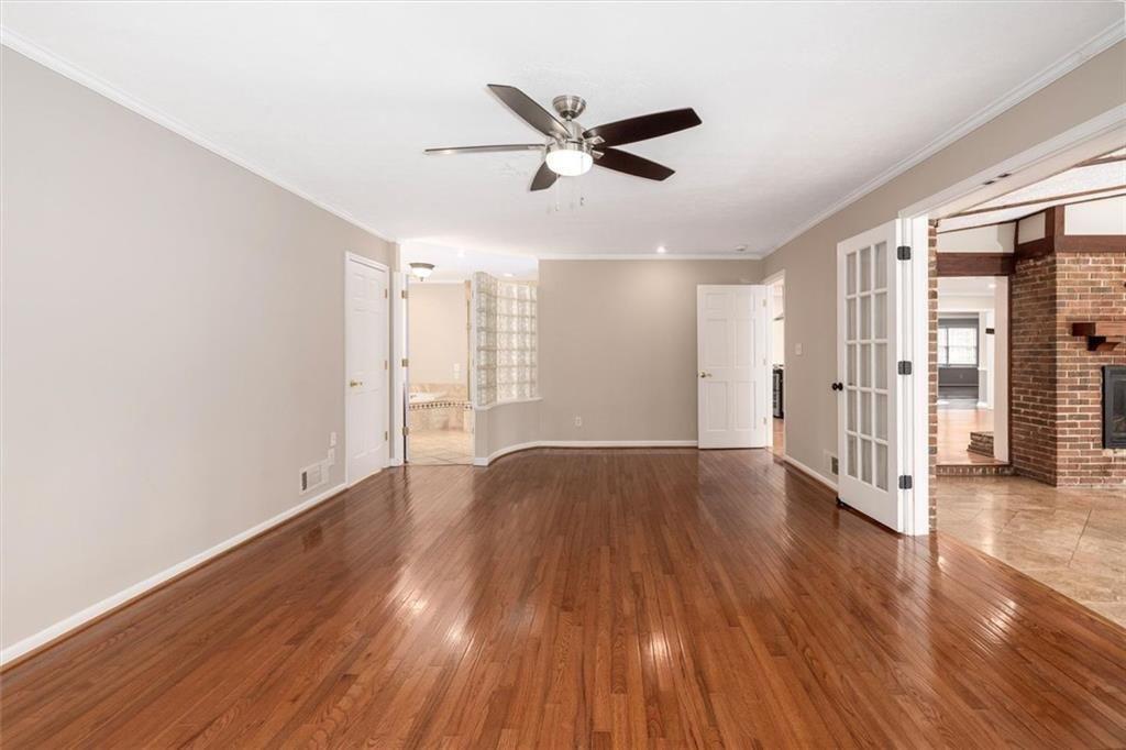 5498 Smoke Rise Drive Smoke Rise, GA 30087 - Photo 18 of 52 a view of an empty room with wooden floor and a ceiling fan