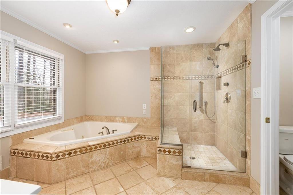 5498 Smoke Rise Drive Smoke Rise, GA 30087 - Photo 19 of 52 a spacious bathroom with a tub a rug and a shower