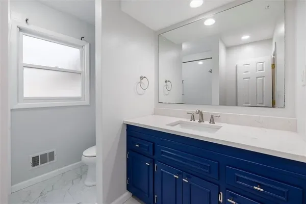 a bathroom with a toilet a sink and mirror