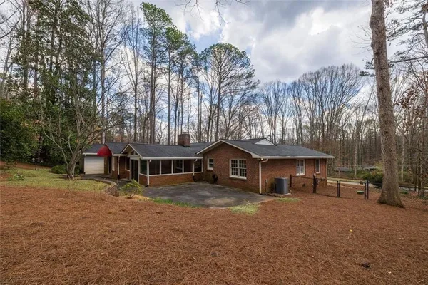 a view of a house with a yard and large trees