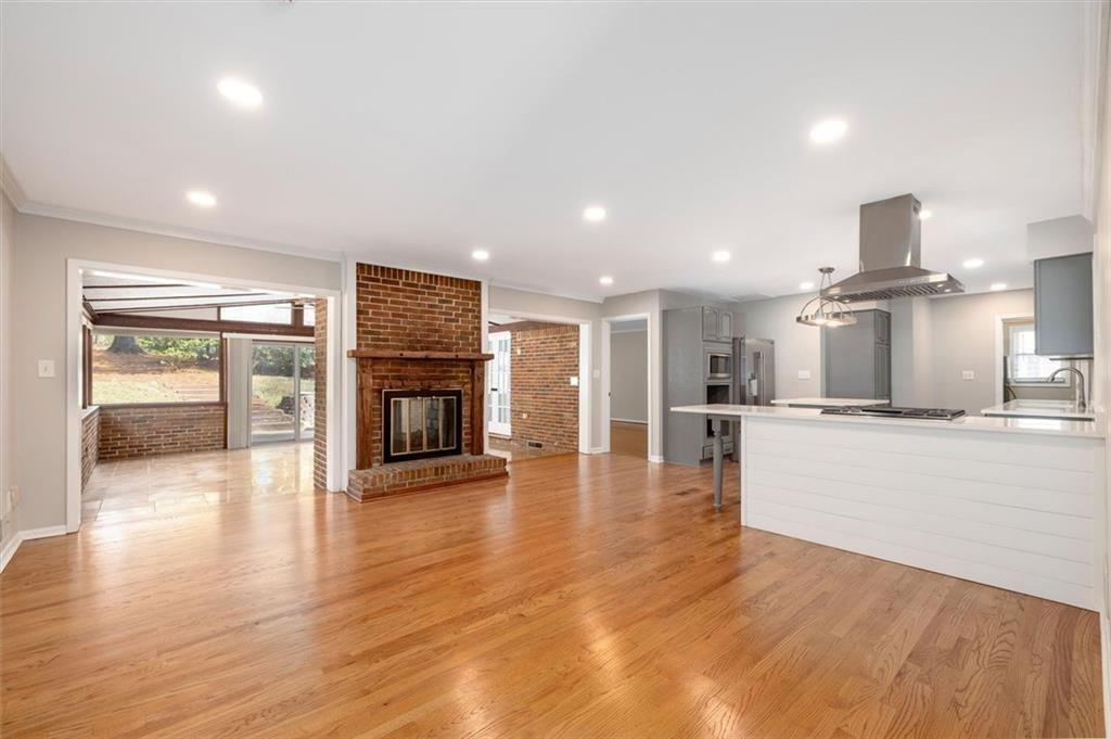 5498 Smoke Rise Drive Smoke Rise, GA 30087 - Photo 8 of 52 an empty room with wooden floor and a kitchen