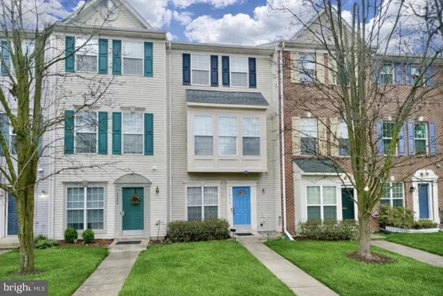 front view of a brick house with a yard