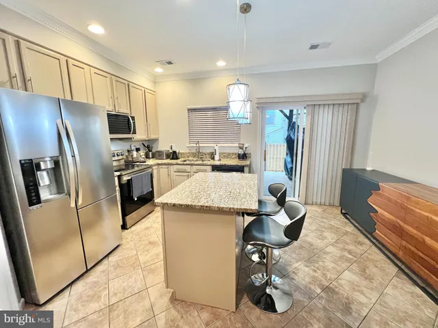 a kitchen with stainless steel appliances granite countertop a refrigerator and a stove top oven