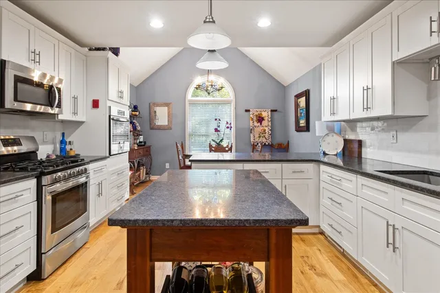 a kitchen with stainless steel appliances granite countertop a sink stove and refrigerator