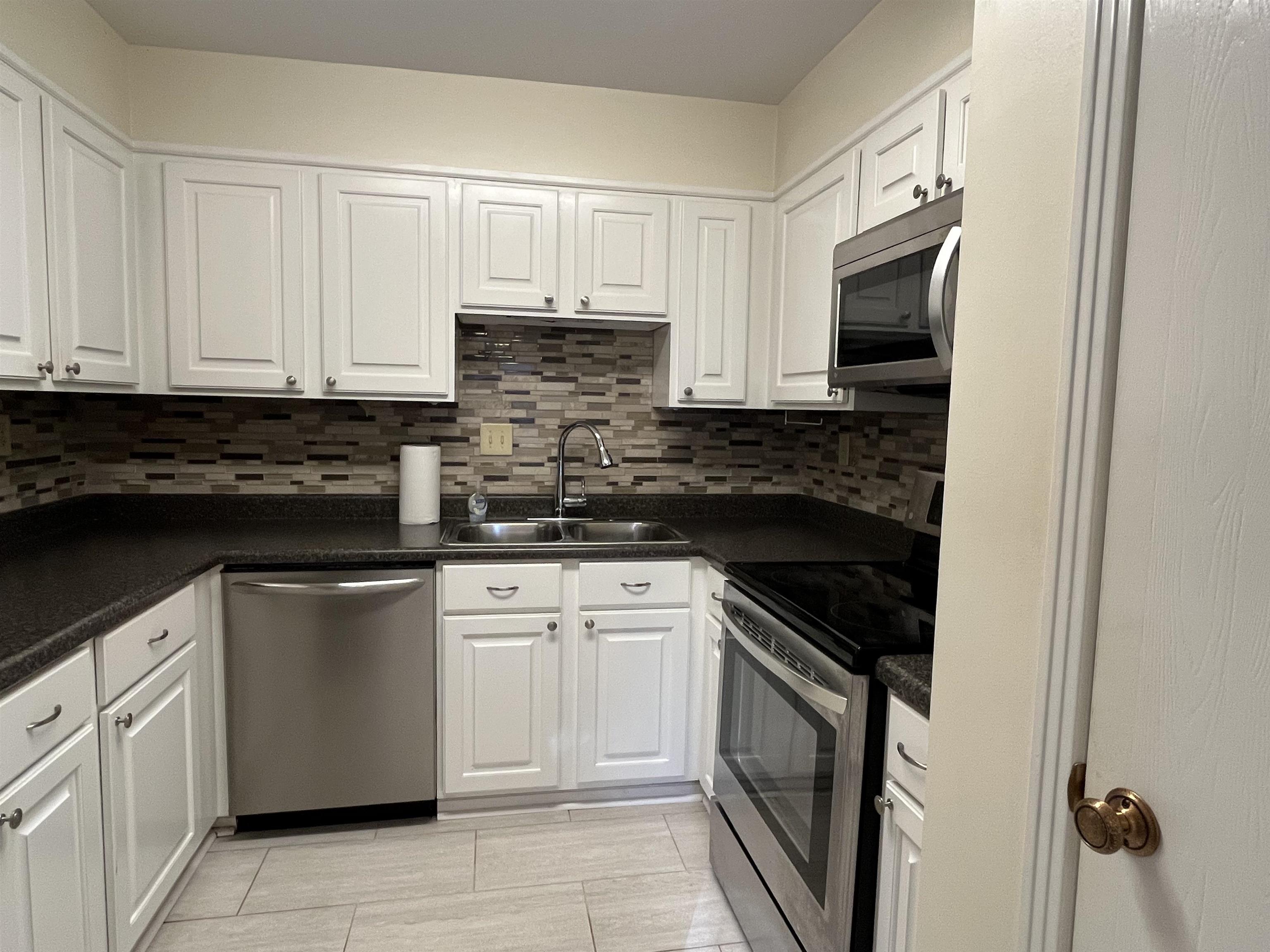 6960 Country Road Germantown, TN 38138 - Photo 13 of 36 a kitchen with white cabinets and stainless steel appliances