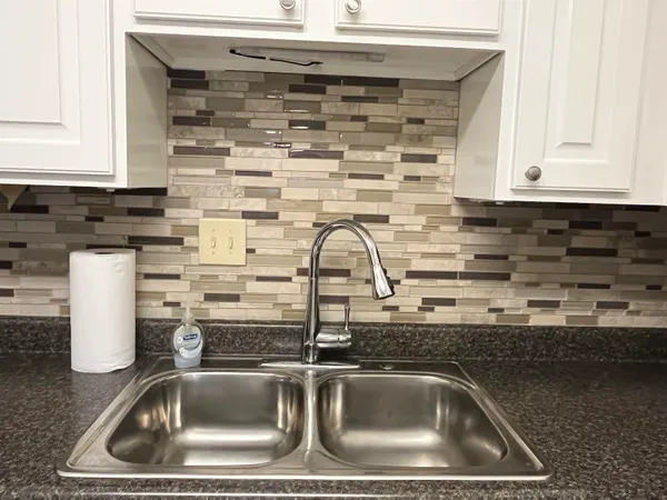 a kitchen with granite countertop a refrigerator and a sink