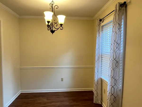 a view of an empty room with window and a ceiling fan
