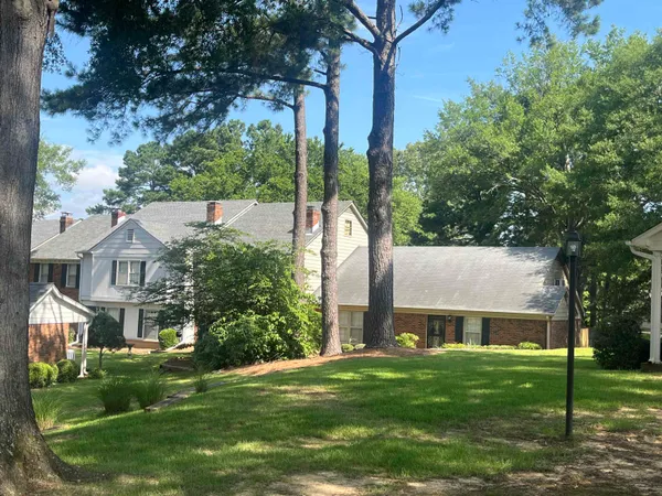 front view of house with a yard and potted plants