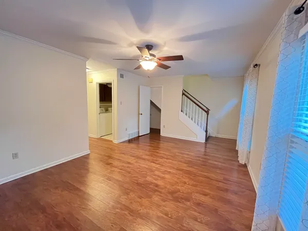 a view of an empty room with window and a ceiling fan