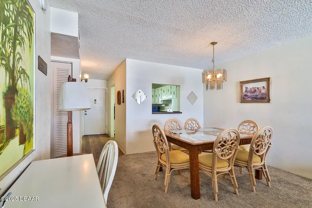 a view of a dining room with furniture and a chandelier
