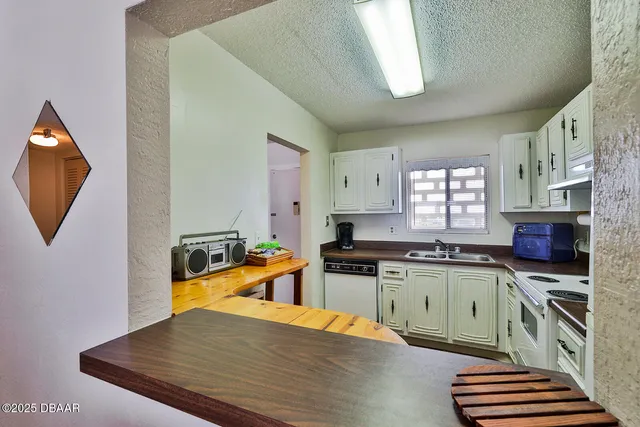 a kitchen with stainless steel appliances granite countertop a stove a refrigerator a sink a stove and white cabinets