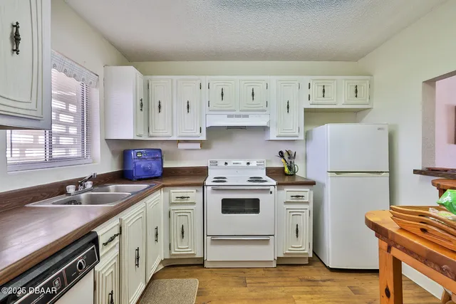 a kitchen with stainless steel appliances granite countertop a refrigerator sink and stove