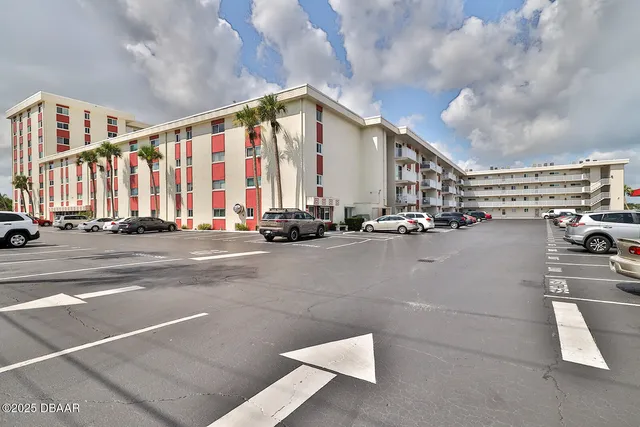 a view of building with yard and sitting area