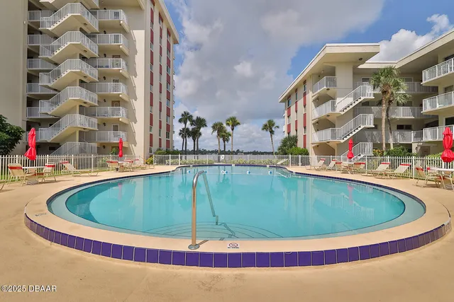 a house view with a swimming pool and sitting space