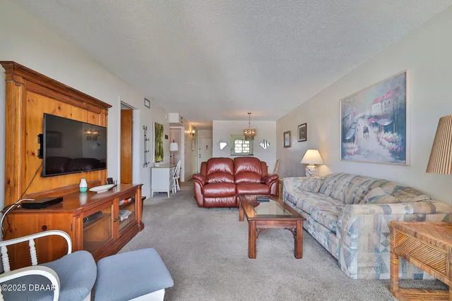 a living room with furniture a flat screen tv and wooden floor