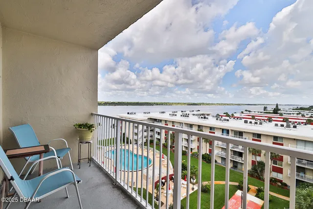 a balcony view with two chairs and a table