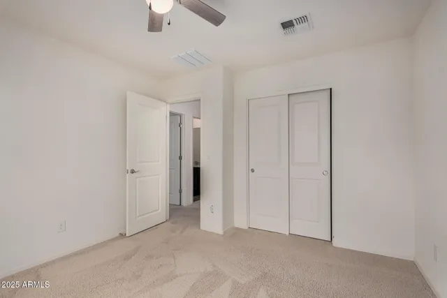 an empty room with a window and a fan