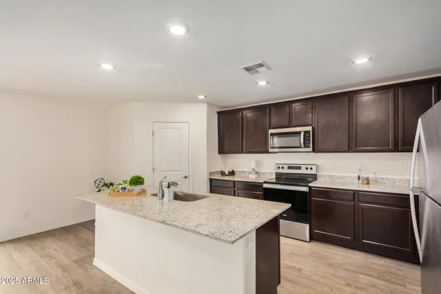 a kitchen with stainless steel appliances granite countertop a sink stove and refrigerator