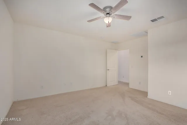 an empty room with a ceiling fan and a fan