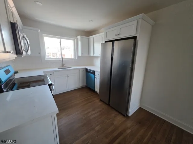 a kitchen with stainless steel appliances a refrigerator a sink a stove a microwave and island