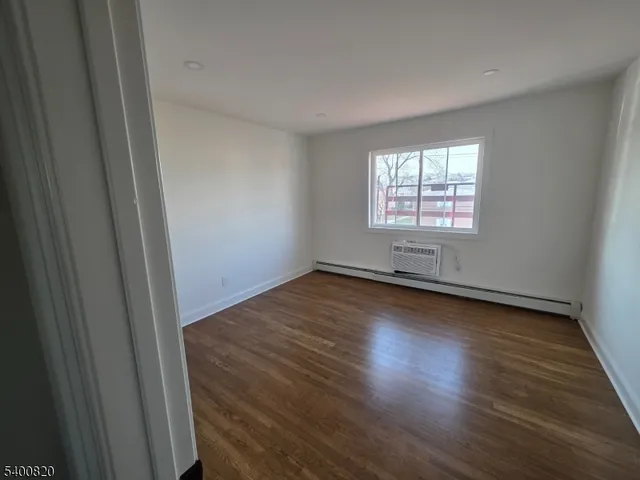 a view of a room with wooden floor and windows