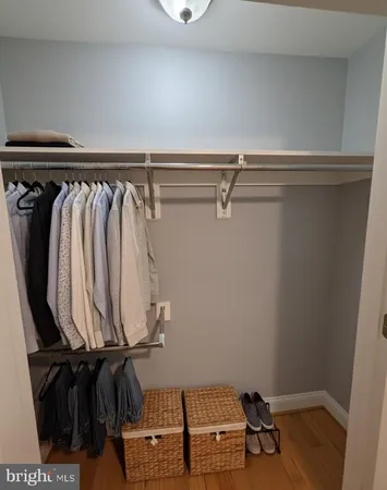 a view of walk in closet with clothes and shoes
