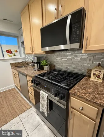 a kitchen with stainless steel appliances a stove a sink and a microwave