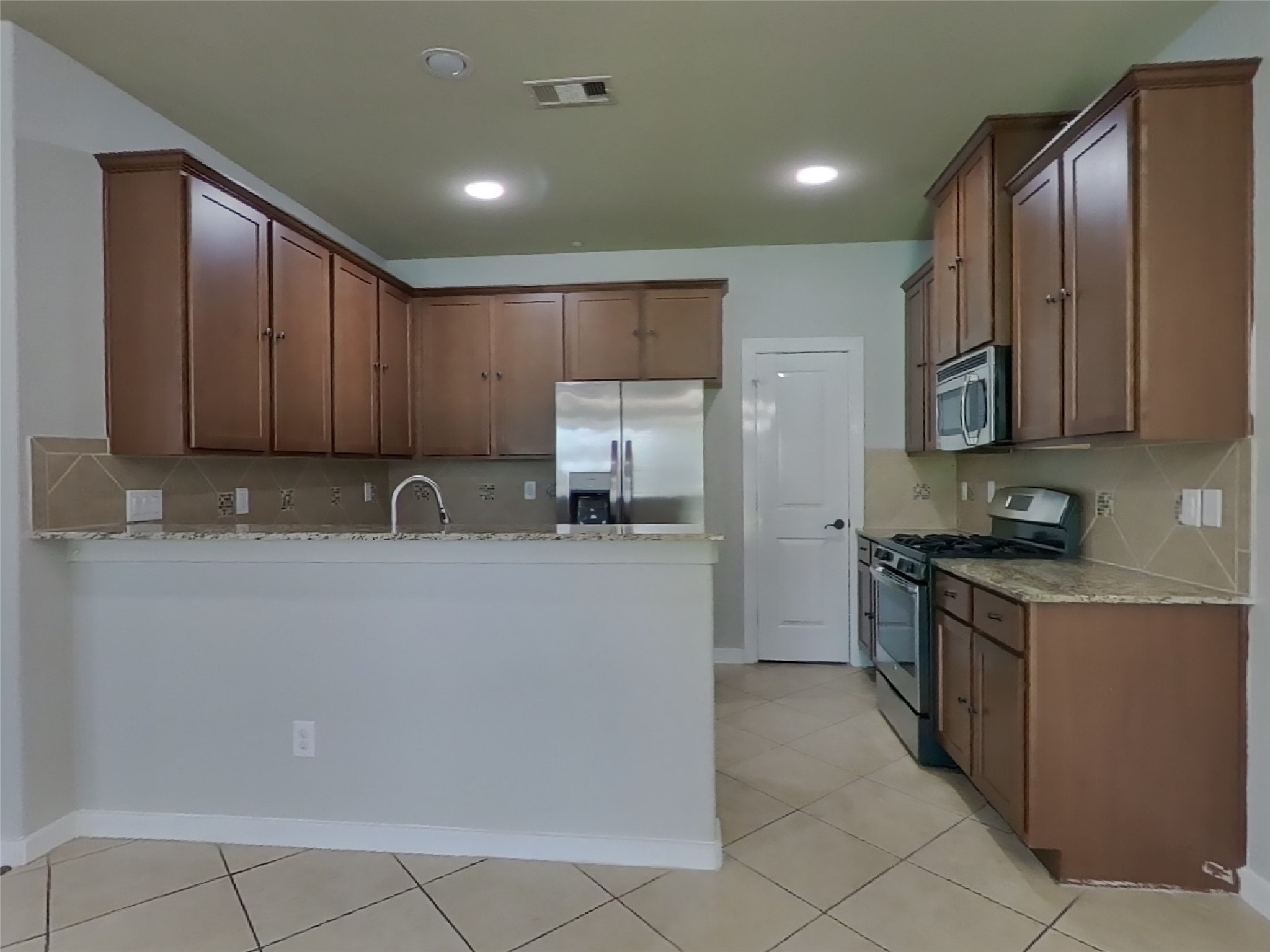1819 Jara Court Spring, TX 77388 - Photo 5 of 19 a large kitchen with stainless steel appliances granite countertop a refrigerator and a stove top oven