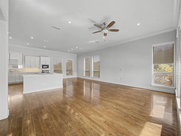 a view of empty room with wooden floor and window