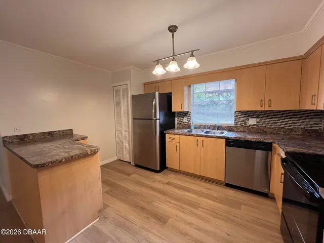 a kitchen with granite countertop a stove cabinets and wooden floor