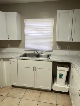 a kitchen with granite countertop white cabinets and white appliances