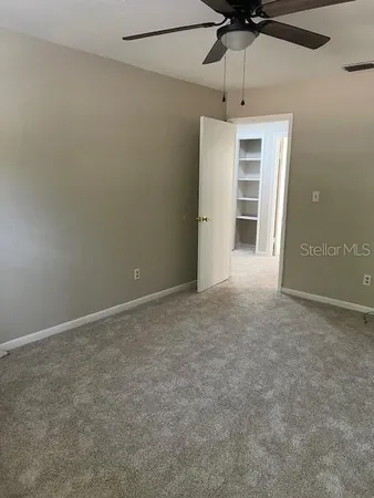 an empty room with a ceiling fan and entryway