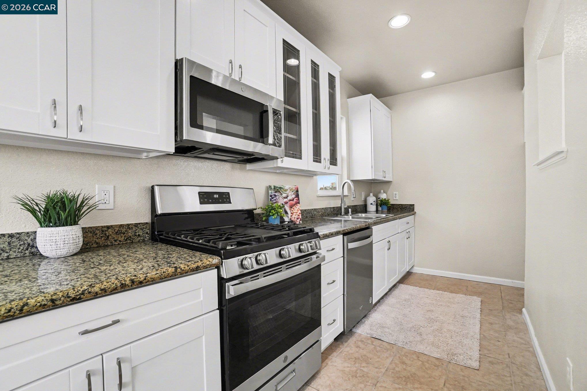 139 Rodeo Avenue Rodeo, CA 94572 - Photo 5 of 19 a kitchen with stainless steel appliances granite countertop a sink a stove a microwave and cabinets