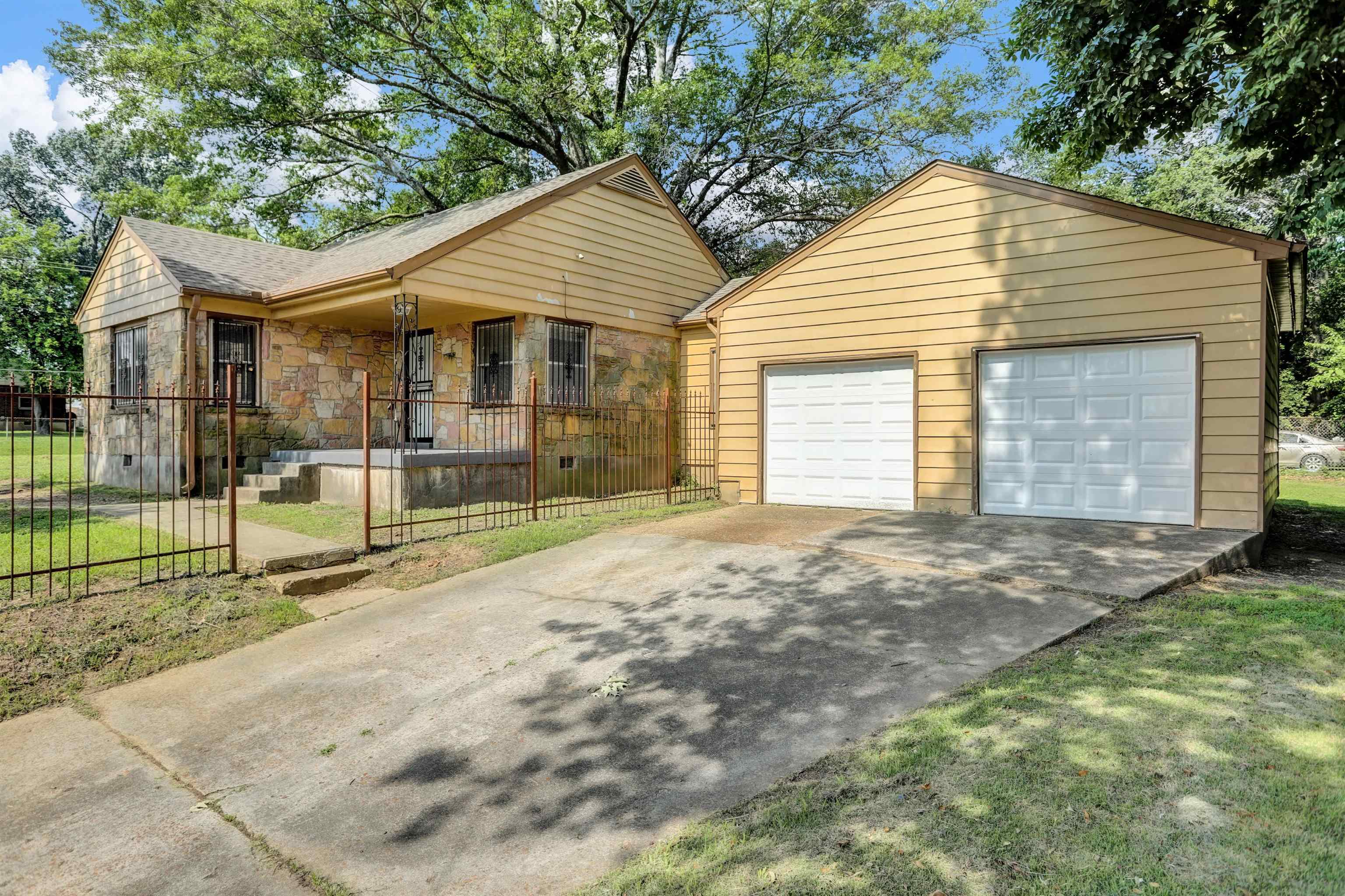 3257 Millington Road Memphis, TN 38127 - Photo 2 of 31 View of front of property with a porch, stone siding, an outdoor structure, a detached garage, and a shingled roof