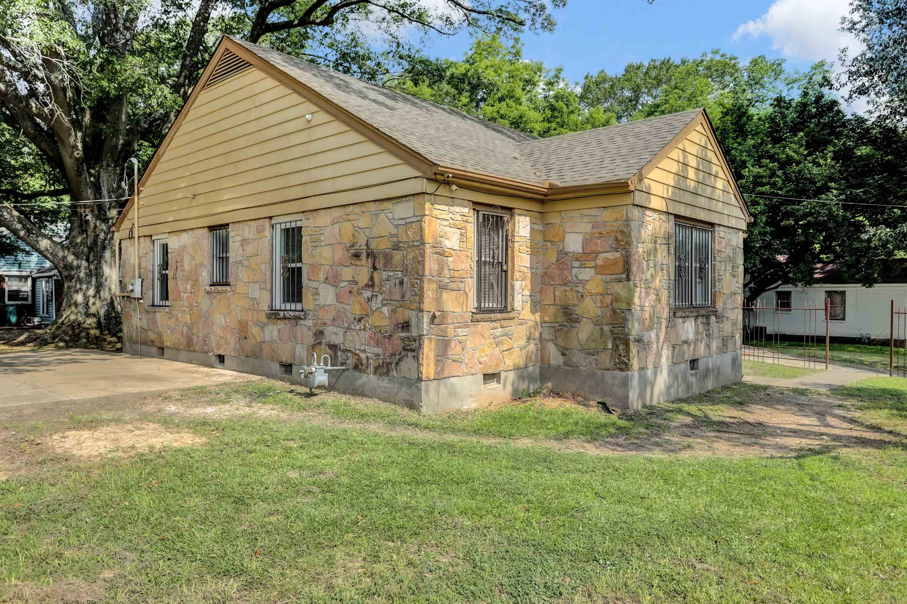 3257 Millington Road Memphis, TN 38127 - Photo 31 of 31 View of home's exterior with crawl space, a shingled roof, stone siding, and a yard